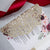 Glitter Gold burgundy laser cut Pocket Fold invitation with Red Satin belly band and Floral backer
